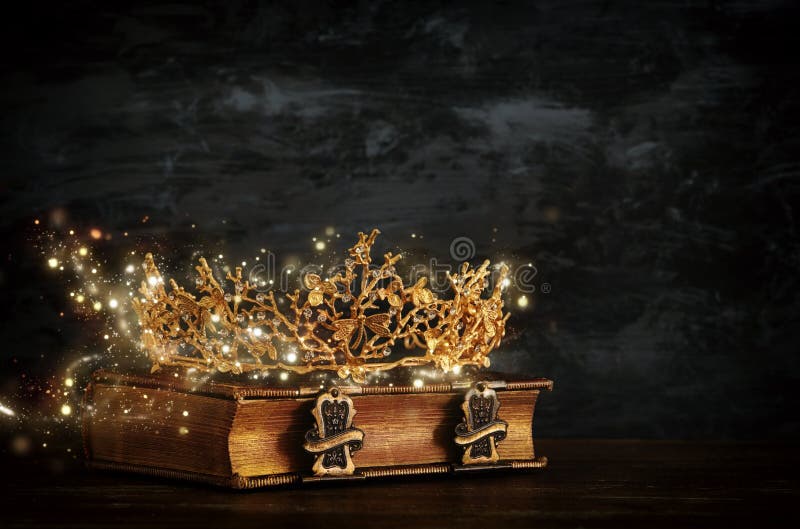 low key image of beautiful queen/king crown on old book. vintage filtered. fantasy medieval period. low key image of beautiful queen/king crown on old book. vintage filtered. fantasy medieval period