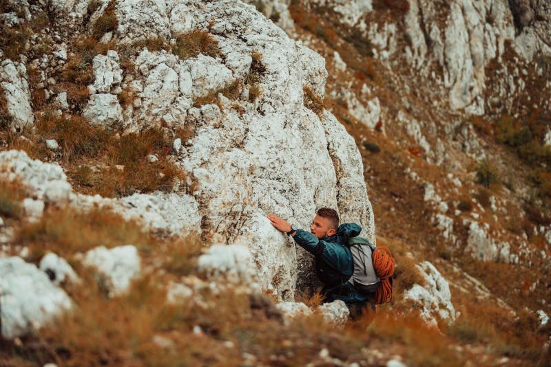 A male climber climbing up on the mountain rock cliff adventure travel adrenaline extreme sport outdoor. Immagini di alta qualità