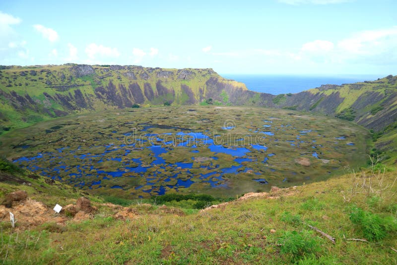 An Immense Crater Lake of Rano Kau View from Orongo Village on Easter Island with Pacific Ocean in the Distance, Chile. Beauty in Nature stock photography An Immense Crater Lake of Rano Kau View from Orongo Village on Easter Island with Pacific Ocean in the Distance, Chile. Beauty in Nature stock photography