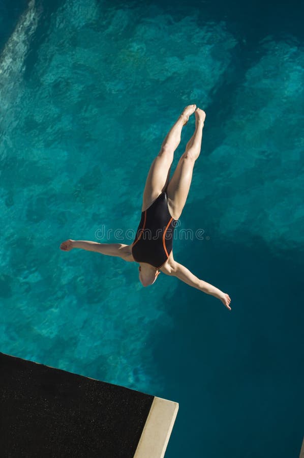 Immersione subacquea femminile del nuotatore nell'a mezz'aria
