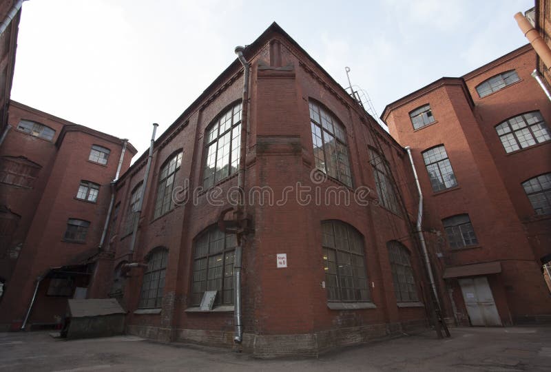 Immeuble de brique rouge industriel de vintage dans la zone industrielle de la vieille ville européenne images stock Immeuble de brique rouge industriel de vintage dans la zone industrielle de la vieille ville européenne images stock