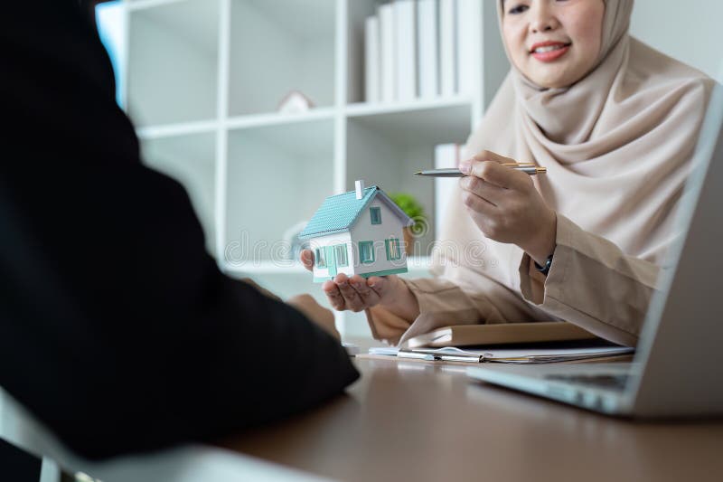 Immobilienmakler erörtern Immobilienverkauf mit Kunden in modernem Büroumfeld stockbilder