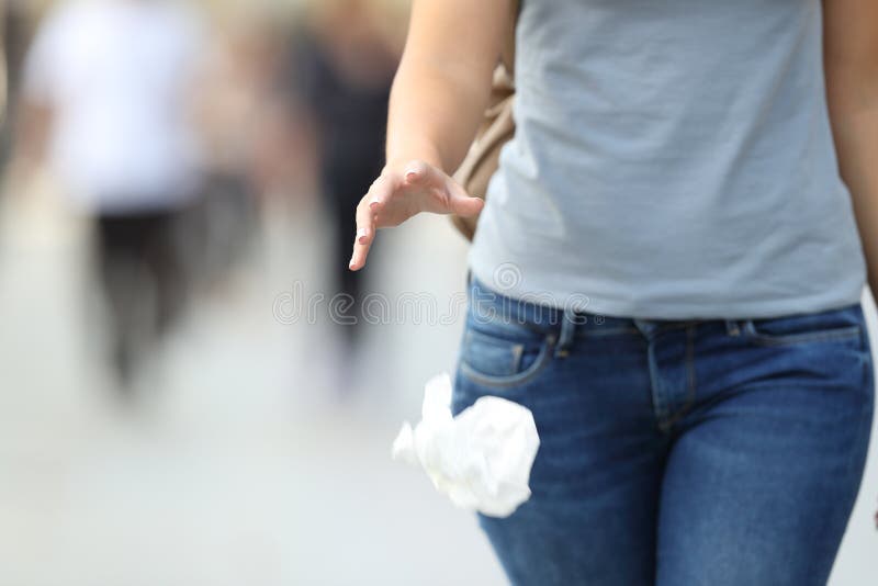 Immondizia di lancio della donna irresponsabile al pavimento immagine stock Immondizia di lancio della donna irresponsabile al pavimento immagine stock