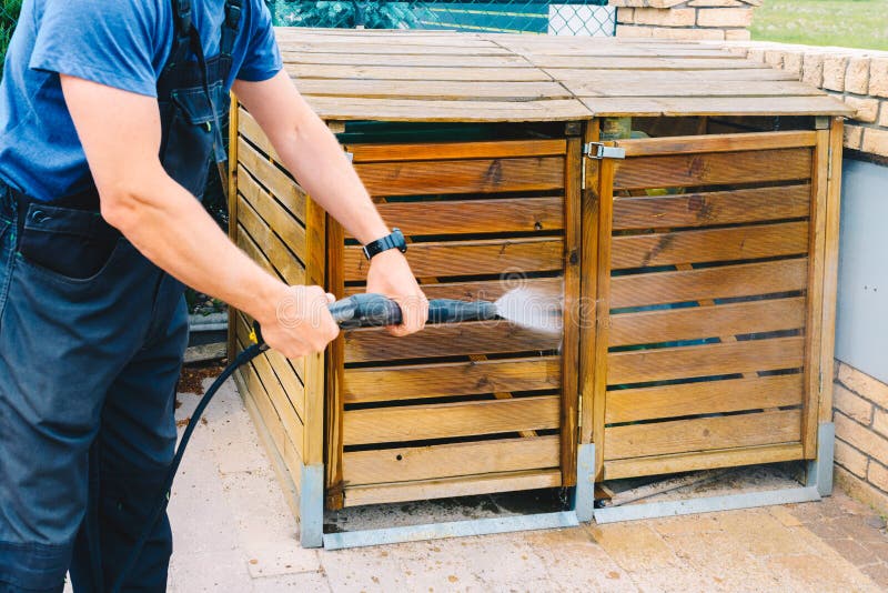 Immondizia di legno sporca di pulizia del giardino con un cleane ad alta pressione fotografia stock libera da diritti Immondizia di legno sporca di pulizia del giardino con un cleane ad alta pressione fotografia stock libera da diritti