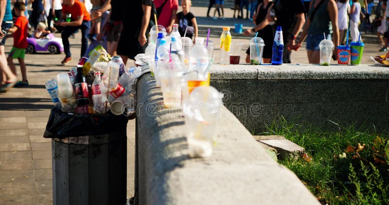 Immondizia e bottiglie vuote nel parco sullo sfondo di molti passanti. un cestino completo sullo sfondo stock footage