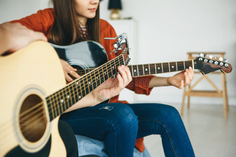 Learning to play the guitar. The teacher explains to the student the basics of playing the guitar. Individual home schooling or extracurricular lessons. Learning to play the guitar. The teacher explains to the student the basics of playing the guitar. Individual home schooling or extracurricular lessons.