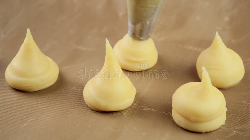 Impasto per ecladi e profiteroli su pergamena, di pasta per pasticceria Chiudi Concetto alimentare video 4k