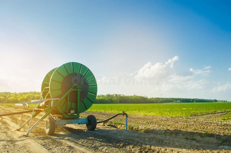 Impianto di irrigazione per l'innaffiatura dei raccolti agricoli con un grande avvolgitore per tubo Grande attrezzatura industria fotografie stock