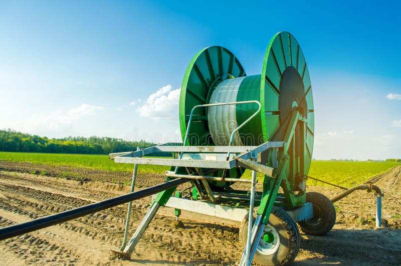 Impianto di irrigazione per l'innaffiatura dei raccolti agricoli con un grande avvolgitore per tubo Grande attrezzatura industria fotografia stock libera da diritti