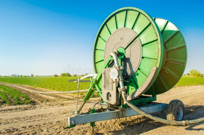 Impianto di irrigazione per l'innaffiatura dei raccolti agricoli con un grande avvolgitore per tubo Grande attrezzatura industria immagine stock libera da diritti