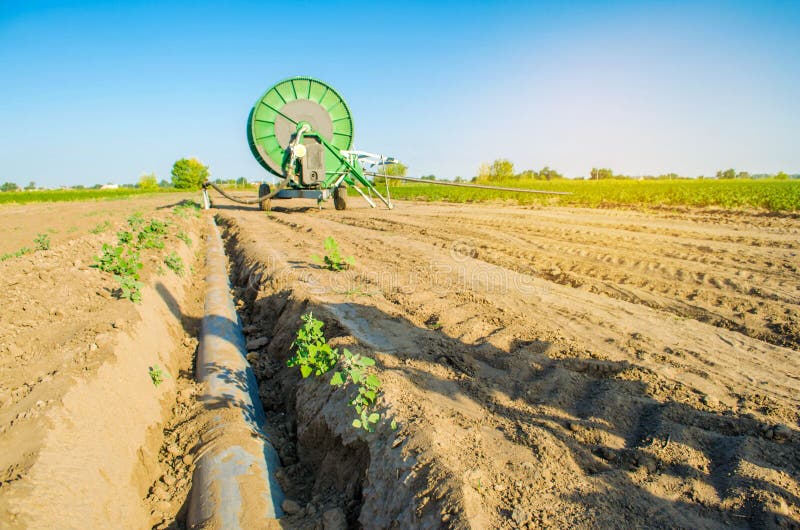 Impianto di irrigazione per l'innaffiatura dei raccolti agricoli con un grande avvolgitore per tubo Grande attrezzatura industria immagini stock