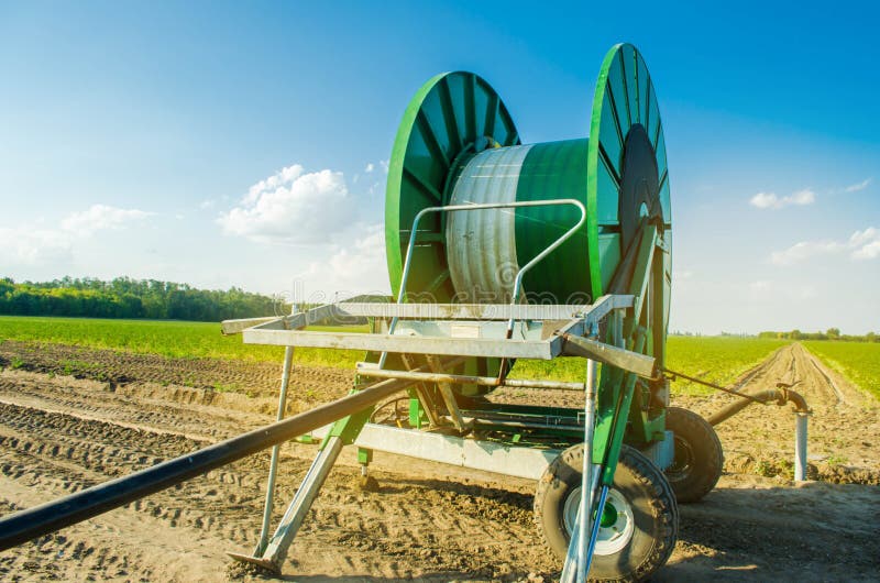 Impianto di irrigazione per l'innaffiatura dei raccolti agricoli con un grande avvolgitore per tubo Attrezzatura industriale per fotografie stock libere da diritti