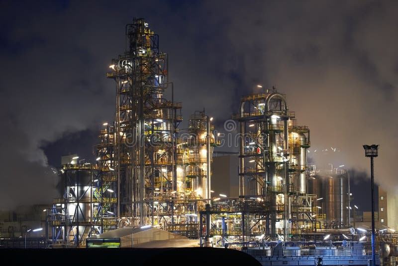 Oil refinery surrounded with steaming fumes. Oil refinery surrounded with steaming fumes