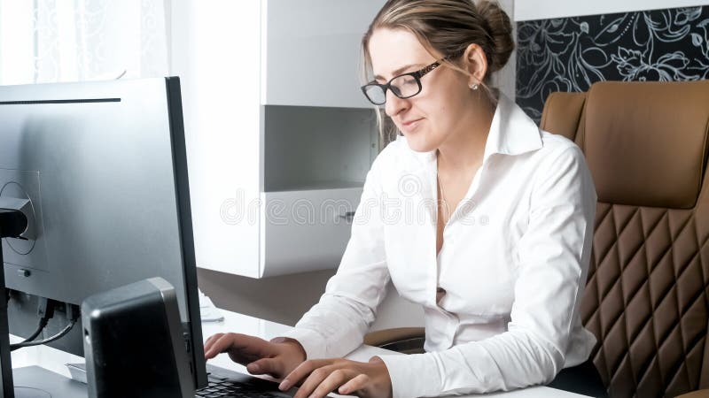 Impiegato di concetto femminile concetrated giovani che per mezzo del computer immagini stock Impiegato di concetto femminile concetrated giovani che per mezzo del computer immagini stock