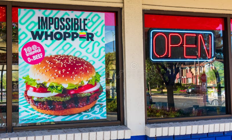 Impossible Whopper poster advertises meatless plant-based substitute food at Burger King fast food restaurant. The vegan burger stock photography