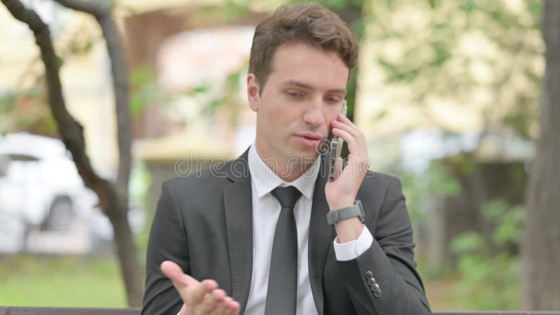 Imprenditore impegnato che parla al telefono all'aperto