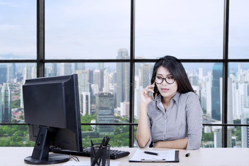 imprenditrice asiatica chiama qualcuno mentre lavora