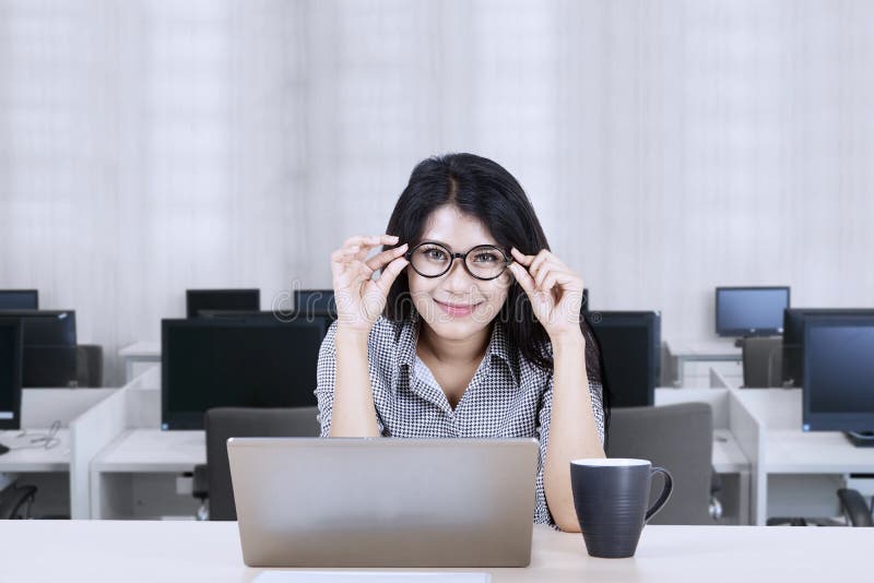 imprenditrice asiatica in posa reggendo gli occhiali