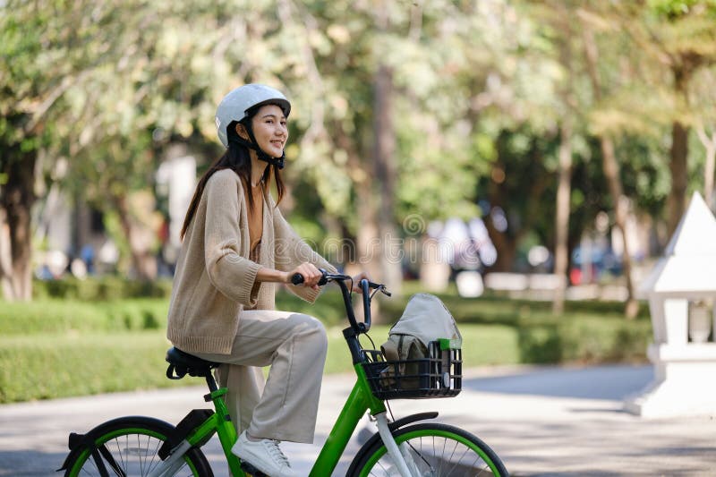 Imprenditrice asiatica va al lavoro in bancarella d'ufficio e porta con sé uno zaino sorridente con la bicicletta. pendolare in bi fotografia stock libera da diritti