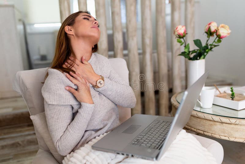 Imprenditrice che sente dolore al collo dopo essersi seduta al tavolo con un portatile. stanca donna che soffre di sindrome da uff immagine stock libera da diritti