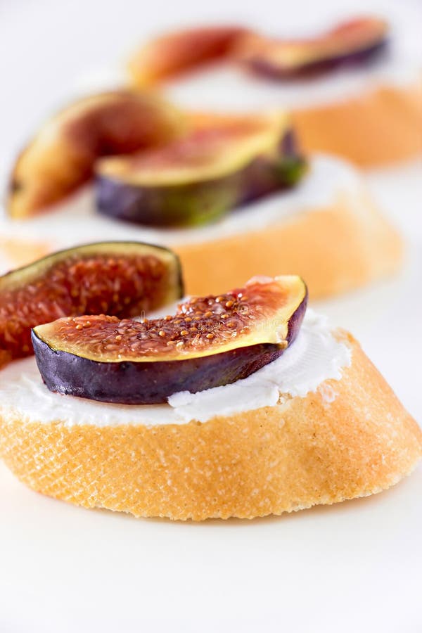 Imprense Bruschetta com figo e queijo de cabra no fundo branco fotos de stock Imprense Bruschetta com figo e queijo de cabra no fundo branco fotos de stock