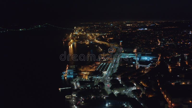 Impresionante vista aérea nocturna de casas y ponte 25 de abril puente rojo en el centro urbano de lisboa portugal metrajes
