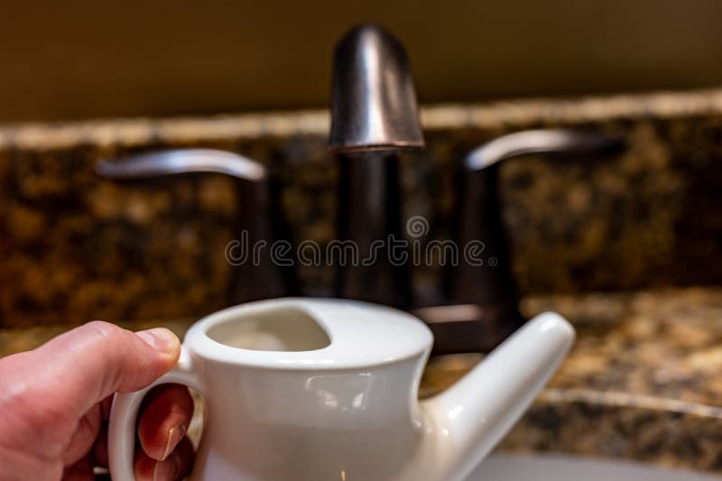 Improperly Filling a Neti Pot with Nonsterile Tap Water. Stock Image