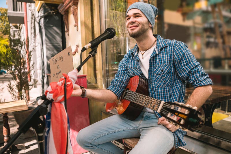 Satisfied male musician begging for tips after play stock photo Satisfied male musician begging for tips after play stock photo