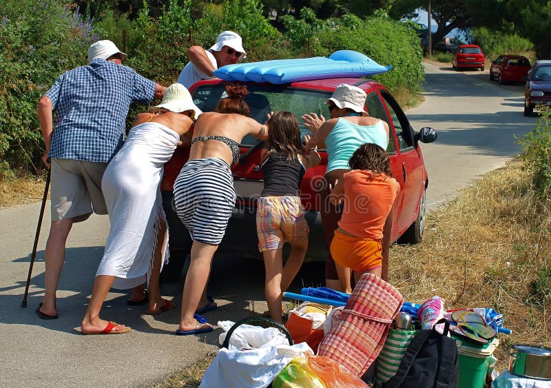 Big family (group people-best friends) have a car defect and pushed him at road in a very hot and sunny summer day. Grandparent with his staff, children, daughter, son,.... On the roof of the car is an air mattress for the beach, and around broken car is a stuff, beach chairs, towels, boxes from the container. Horizontal color photo. Big family (group people-best friends) have a car defect and pushed him at road in a very hot and sunny summer day. Grandparent with his staff, children, daughter, son,.... On the roof of the car is an air mattress for the beach, and around broken car is a stuff, beach chairs, towels, boxes from the container. Horizontal color photo.