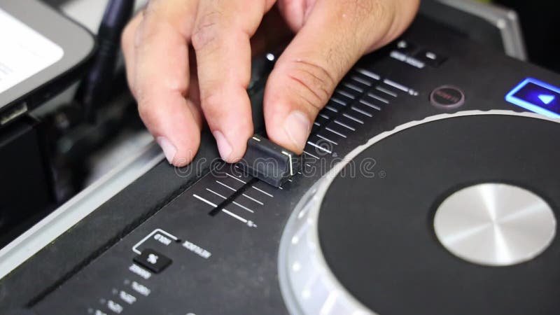 Imágenes de cierre de la mano del DJ aumentando el volumen en el mezclador del DJ almacen de video
