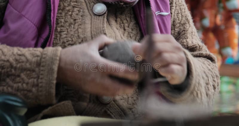 Imágenes de cierre de mujeres de edad avanzada rodando un cubo de lana para hilados almacen de video