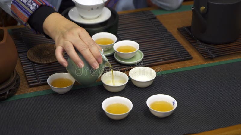 Imágenes de clausura de Té chino vertido en tazas blancas almacen de metraje de vídeo