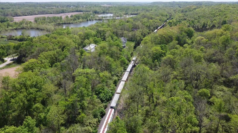 4. 000 imágenes de drones tras un tren que se mueve con árboles y campos en un día soleado almacen de video