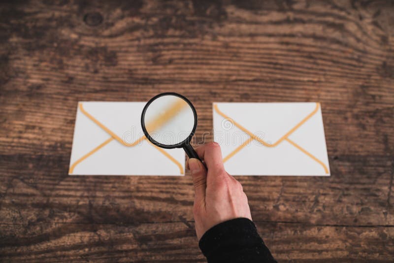 Inbox organisation, email icons side by side and hand holding magnifying glass to analyse and filter them. Inbox organisation conceptual image, email icons side royalty free stock photography Inbox organisation, email icons side by side and hand holding magnifying glass to analyse and filter them. Inbox organisation conceptual image, email icons side royalty free stock photography