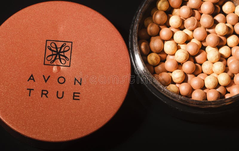Incandescenza di Avon che bronza le perle isolate su fondo scuro fotografia stock Incandescenza di Avon che bronza le perle isolate su fondo scuro fotografia stock