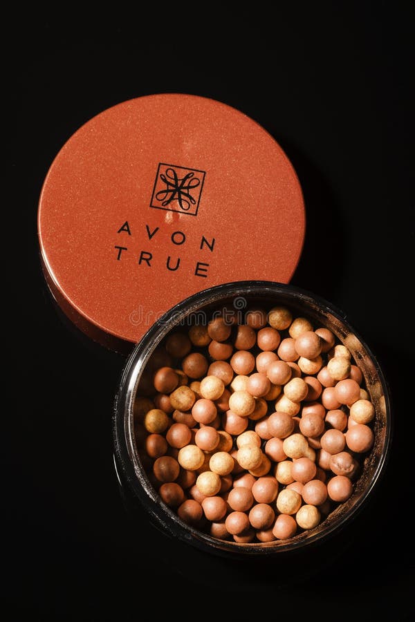 Incandescenza di Avon che bronza le perle isolate su fondo scuro fotografia stock libera da diritti Incandescenza di Avon che bronza le perle isolate su fondo scuro fotografia stock libera da diritti