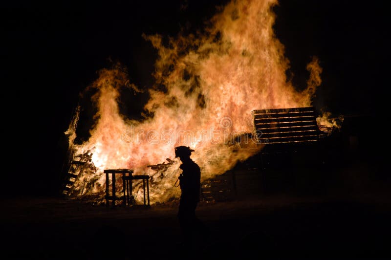 Bonfires rage as a fireman looks on. Bonfires rage as a fireman looks on.