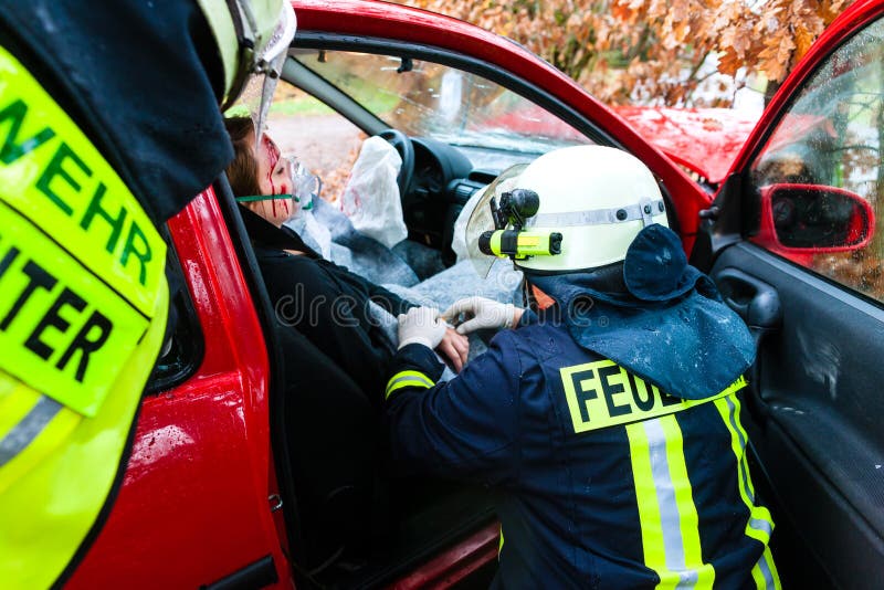 Incidente - i vigili del fuoco salvano la vittima di un incidente stradale fotografia stock Incidente - i vigili del fuoco salvano la vittima di un incidente stradale fotografia stock