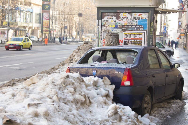 Abandoned car covered with snow after a car accident in Bucharest . Abandoned car covered with snow after a car accident in Bucharest