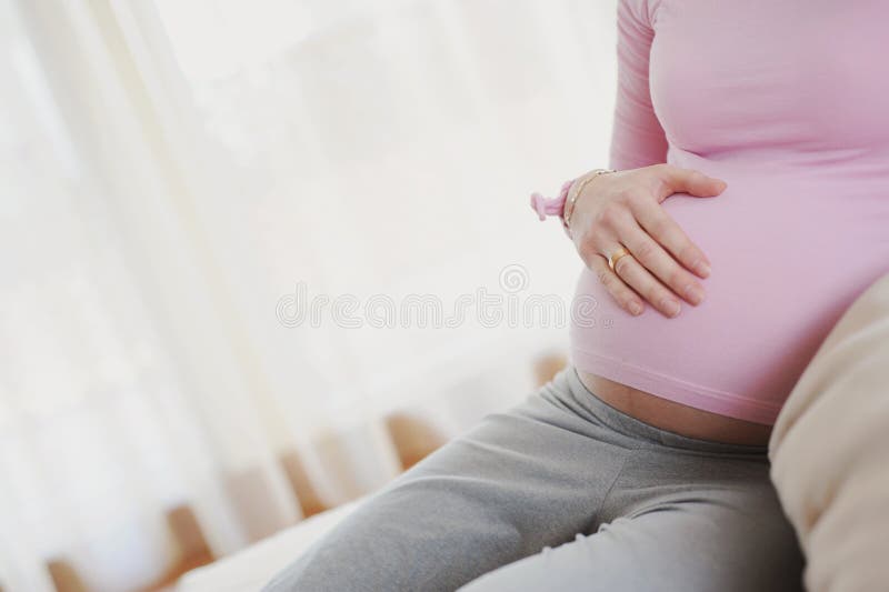 Pregnant lady lay her hand on a stomach. Pregnant lady lay her hand on a stomach