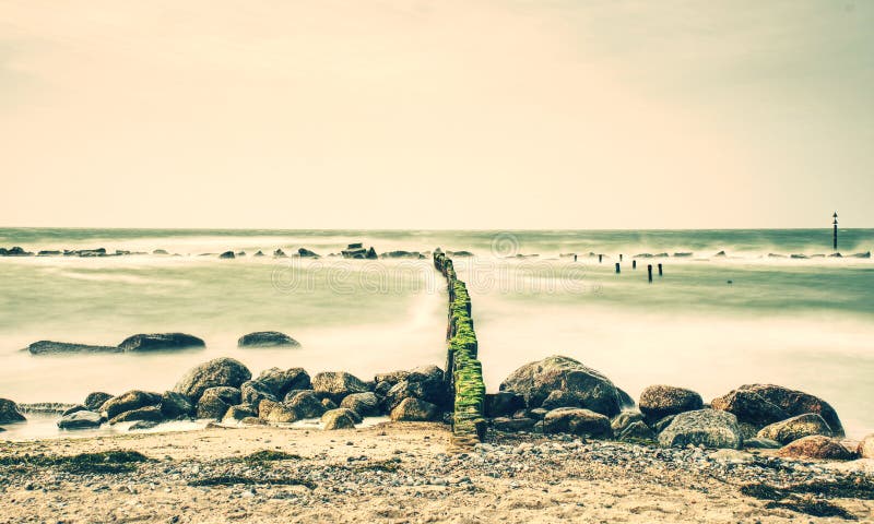 Incoming waves hitting vintage old wood at the coast. Long exposure royalty free stock photo Incoming waves hitting vintage old wood at the coast. Long exposure royalty free stock photo