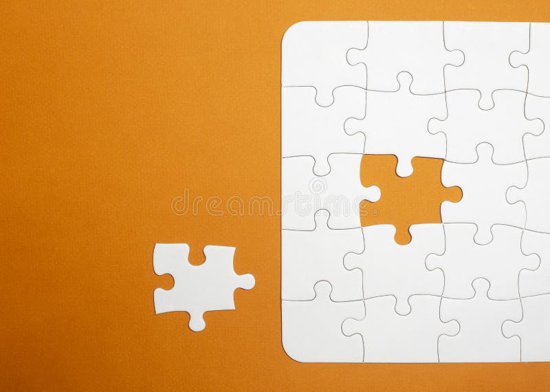 A puzzle is missing two pieces to be completed in different colors. white  pieces and one piece in green and one in orange to add text Stock Photo -  Alamy