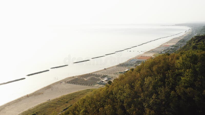 Incredibile ripresa aerea di Green Tree Mountain Hill con una straordinaria vista sulla spiaggia estiva del Mediterraneo in Itali