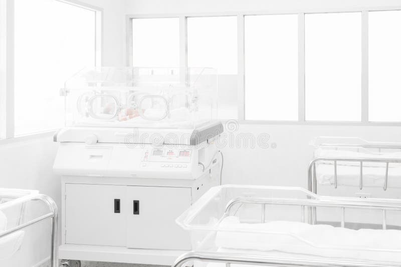 Newborn baby covered inside incubator in hospital post-delivery room. Newborn baby covered inside incubator in hospital post-delivery room.