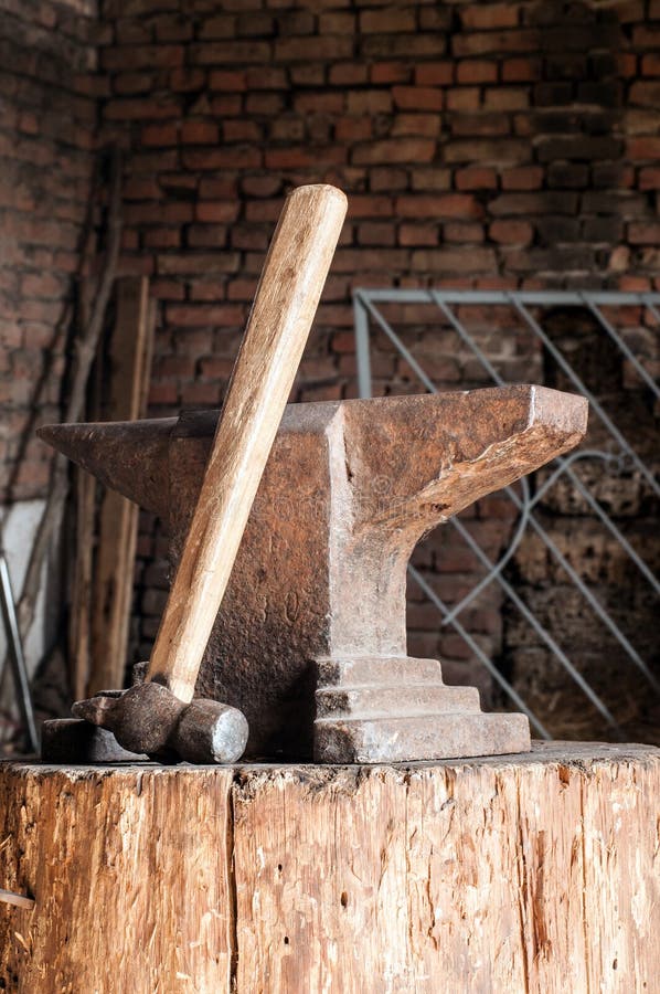 Incudine e martello rustici sul ceppo di legno