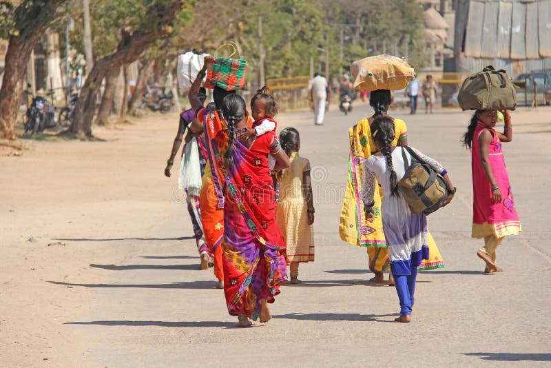 India Hampi - 1 Februari, 2018 Een menigte van Indische mannen en vrouwen van de rug in saris op de straten van India Heldere kle stock afbeelding India Hampi - 1 Februari, 2018 Een menigte van Indische mannen en vrouwen van de rug in saris op de straten van India Heldere kle stock afbeelding