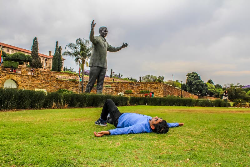 An Indian Asian young male taking rest in front of Nelson Mandela stock photo An Indian Asian young male taking rest in front of Nelson Mandela stock photo