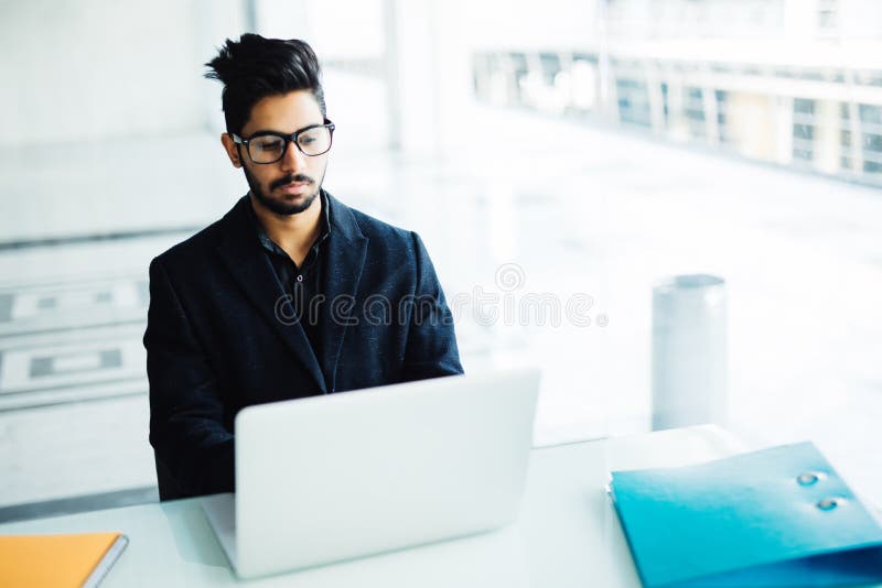 Indian business man working on laptop in modern office stock photography Indian business man working on laptop in modern office stock photography