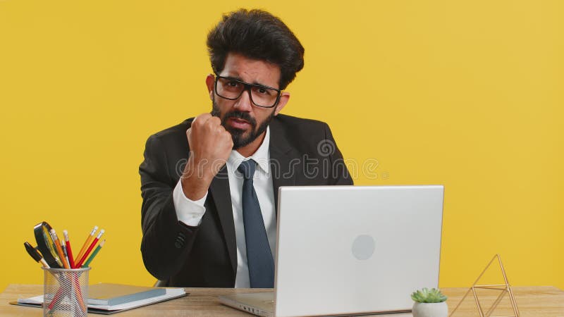 Indian businessman trying to fight at camera, shaking fist, boxing with expression, punishment