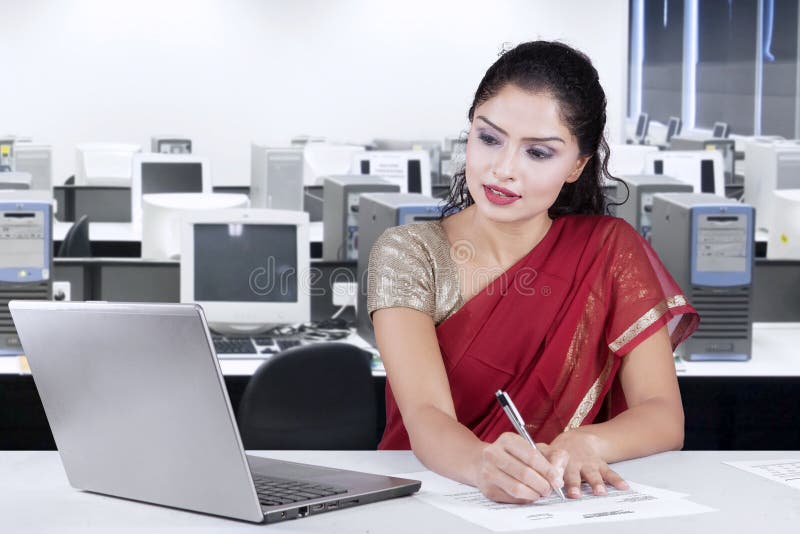 Indian businesswoman writing document in office stock photography Indian businesswoman writing document in office stock photography